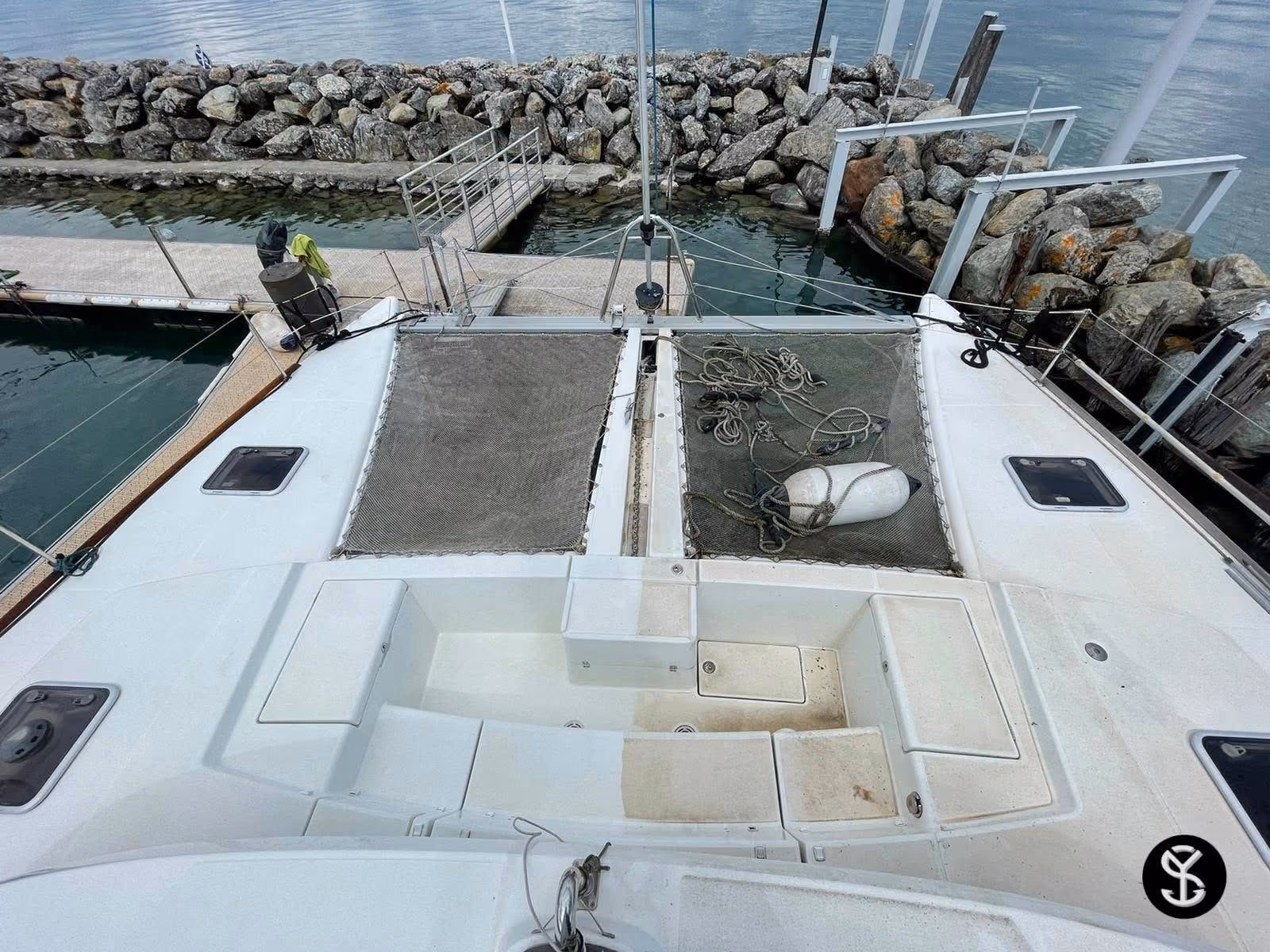 Pont avant d'un catamaran amarré au port, vu depuis le mât