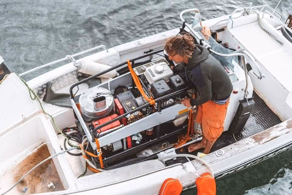 Stéphane Badea à bord du bateau d'intervention, penché sur le matériel de nettoyage vapeur embarqué