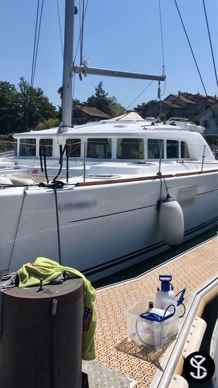Matériel de nettoyage vapeur posé sur le ponton, le long de la coque d'un catamaran amarré